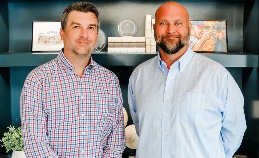 Jeff Thomas and David Aronstein stand in front of a bookcase