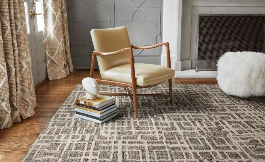 a modern chair on top of a neutral patterned area rug