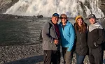 Four adults in front of a waterfall 