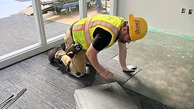 Edgar Diaz installing carpet tile
